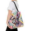 A woman wearing a white t-shirt and black pants carries a colorful tote bag featuring a stylized, geometric French Bulldog illustration. The bag has a black shoulder strap and is shown against a plain white background.