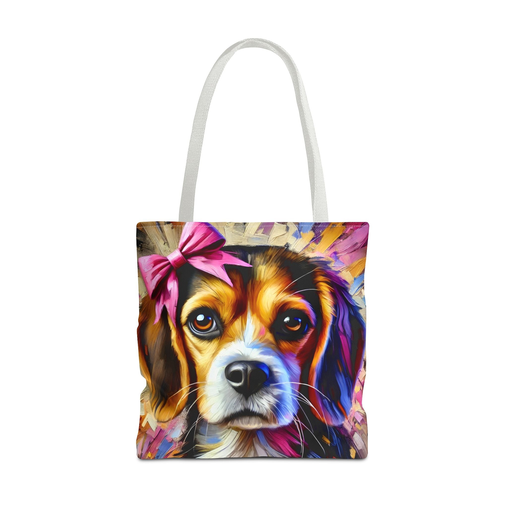 A tote bag with white shoulder straps, featuring a colorful, stylized painting of a beagle's face with a pink bow on the front, set against a plain white background.
