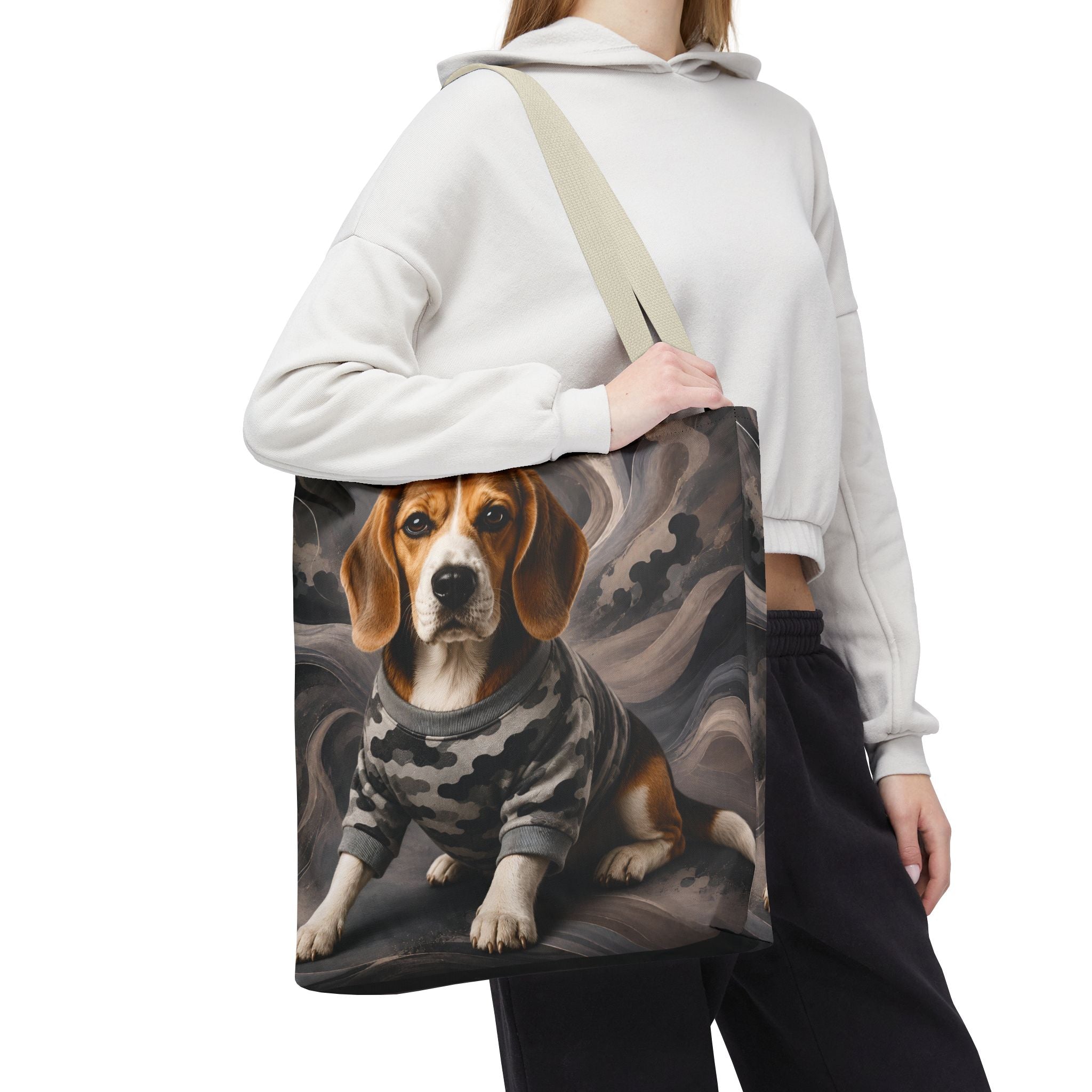 A person wearing a white cropped hoodie and black sweatpants carries a canvas tote bag over their shoulder. The tote bag features a printed illustration of a beagle dog wearing a gray and black camouflage sweater, set against a dark, smoky background.