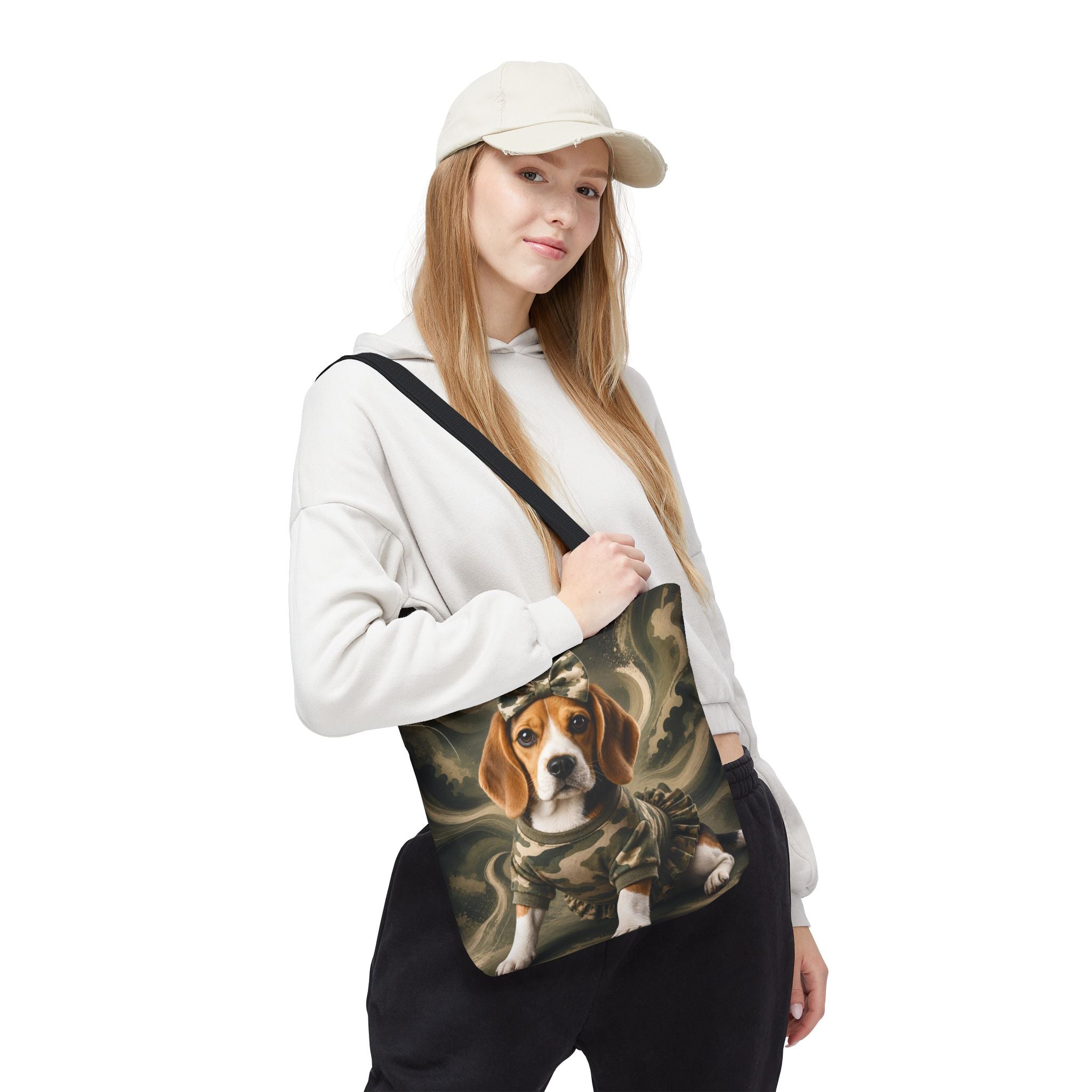 A woman wearing a beige cap, white hoodie, and black sweatpants carries a black shoulder bag featuring a printed illustration of a beagle dog in a military uniform against a dark, smoky background.