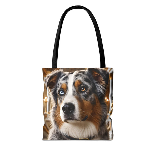 A tote bag with black handles featuring a printed portrait of an Australian Shepherd dog with one blue eye and one brown eye, set against a plain white background.