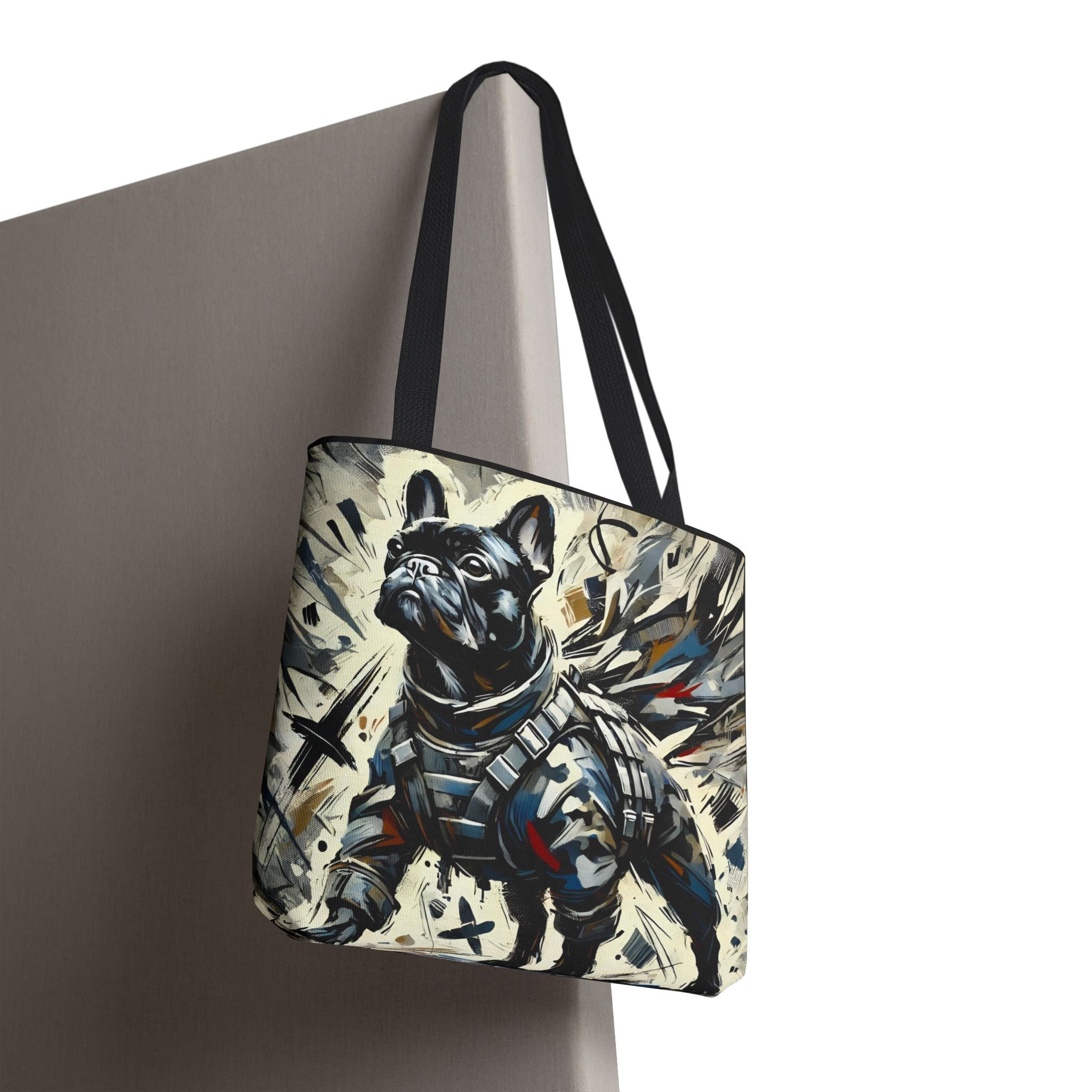 A tote bag with black shoulder straps, featuring a stylized graphic print of a French Bulldog in a tactical armor design, hanging against a neutral gray background.