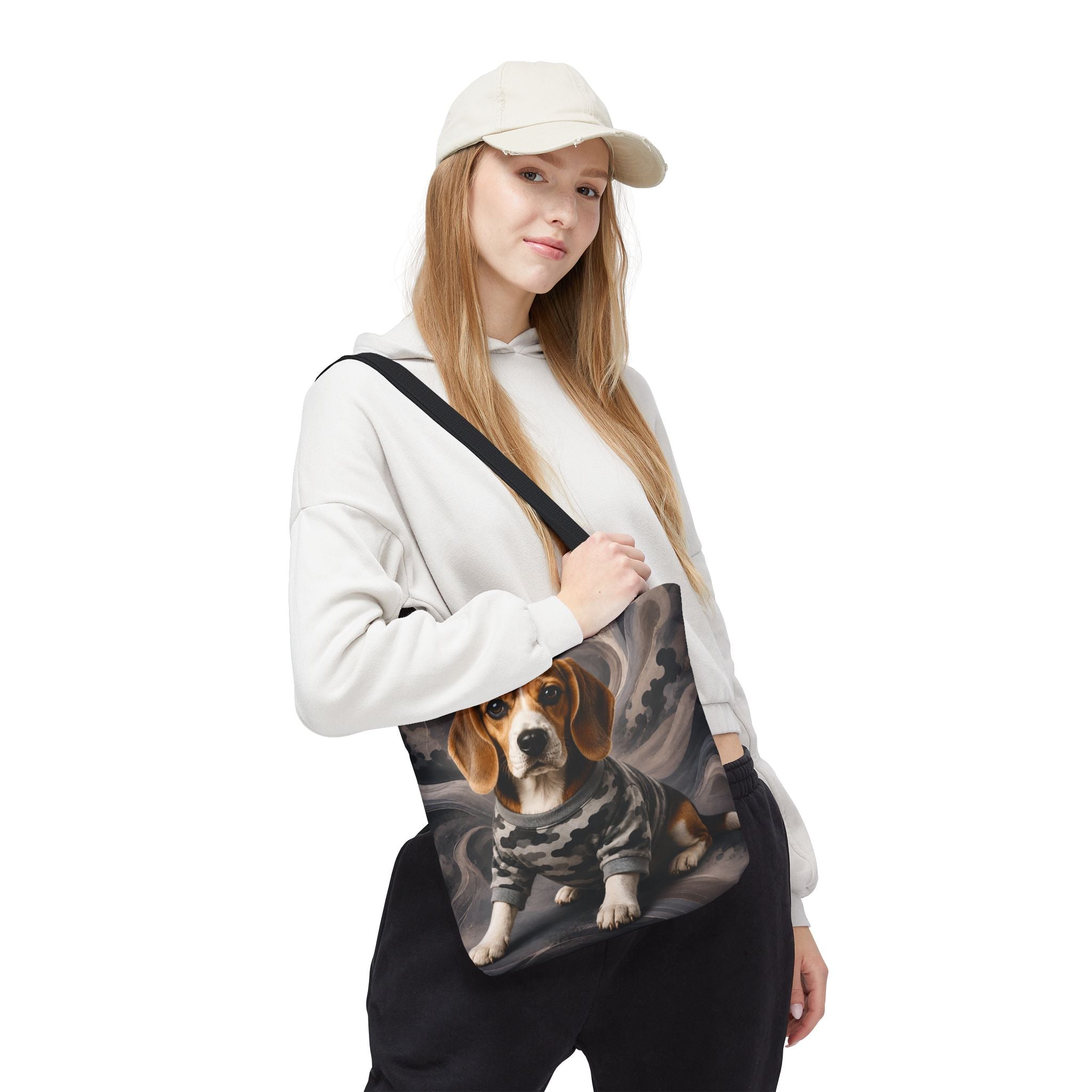 A woman wearing a beige cap, white hoodie, and black sweatpants carries a black shoulder bag featuring a printed graphic of a beagle dog in a camouflage jacket against a smoky gray background.