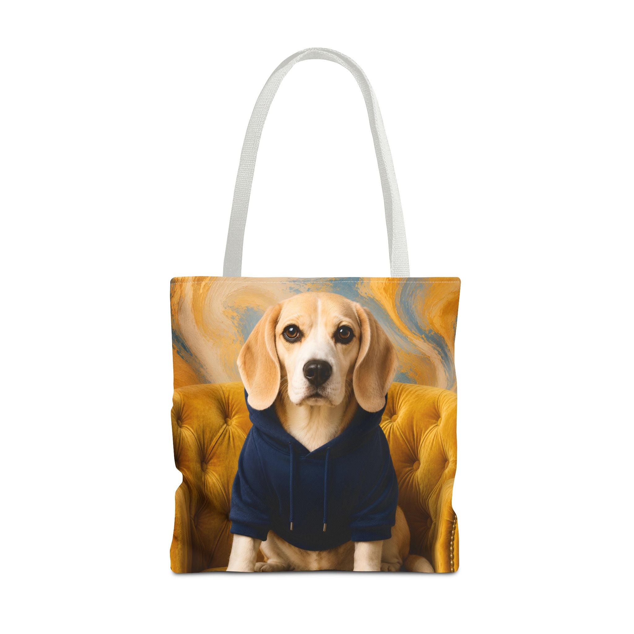 A tote bag with white handles, featuring a printed graphic of a beagle dog wearing a navy blue hoodie and sitting on a yellow tufted chair against a swirling gold and blue background.