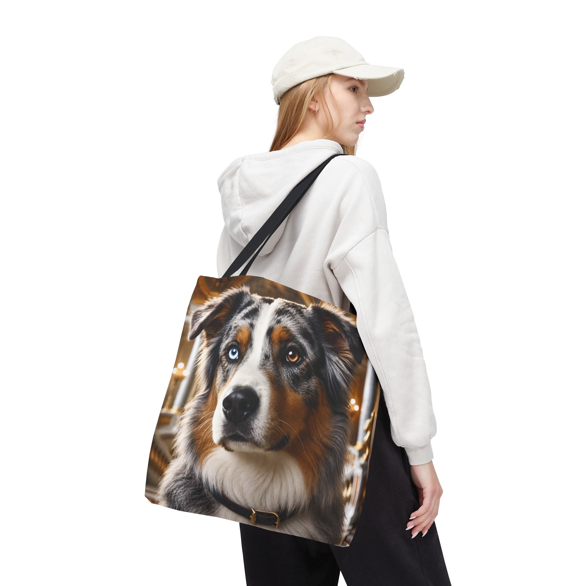 A tote bag with black handles featuring a printed portrait of an Australian Shepherd dog with one blue eye and one brown eye, set against a plain white background.