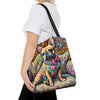 A woman wearing a white t-shirt and black pants carries a colorful tote bag featuring a stylized French Bulldog surrounded by vibrant, swirling psychedelic patterns in yellow, blue, pink, green, and orange.