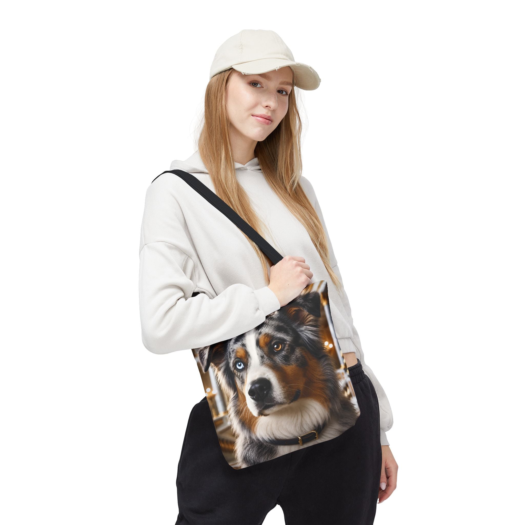 A tote bag with black handles featuring a printed portrait of an Australian Shepherd dog with one blue eye and one brown eye, set against a plain white background.