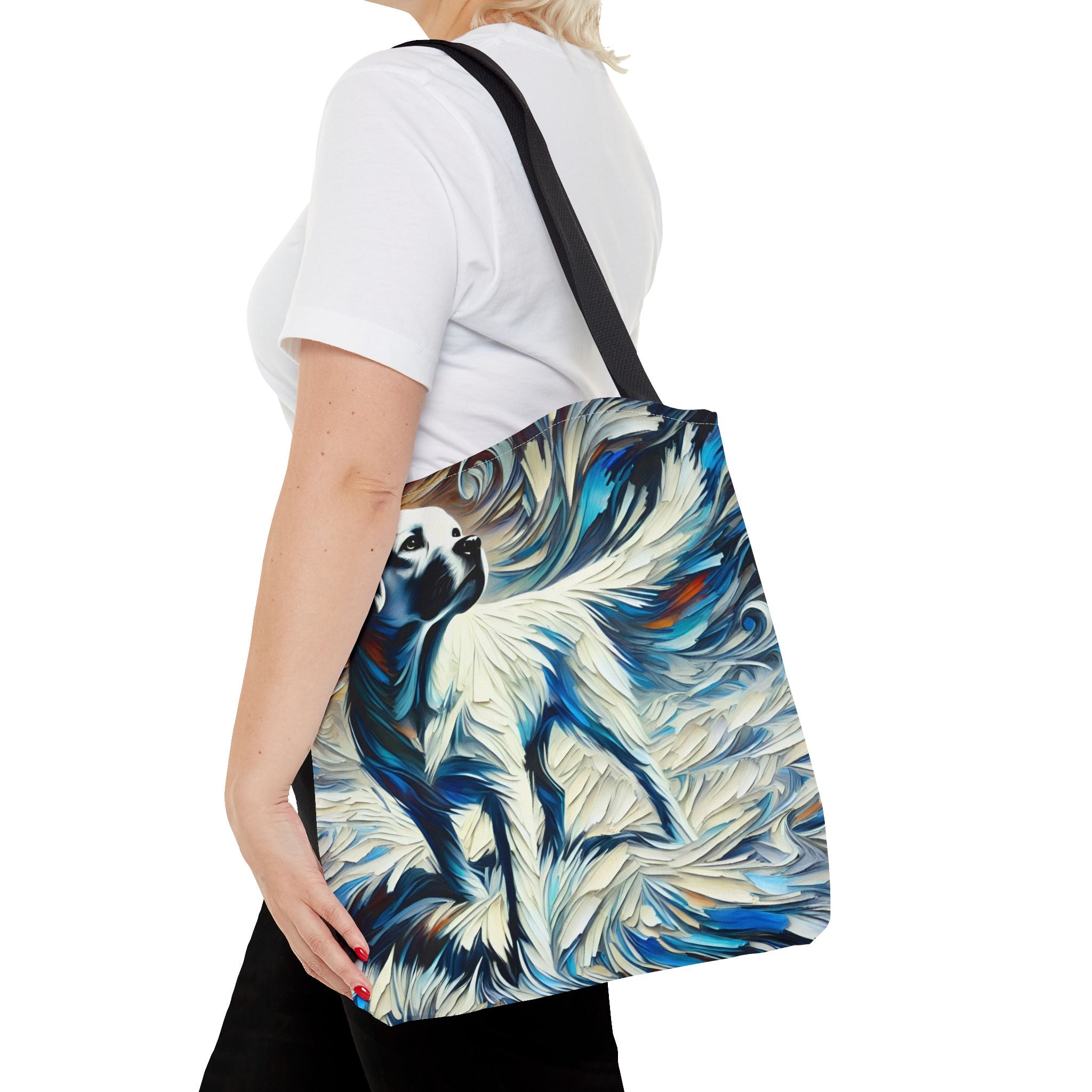 A woman wearing a carries a canvas tote bag with a black shoulder strap. The bag features a detailed, textured painting of a white Labrador retriever with blue and white brushstrokes.