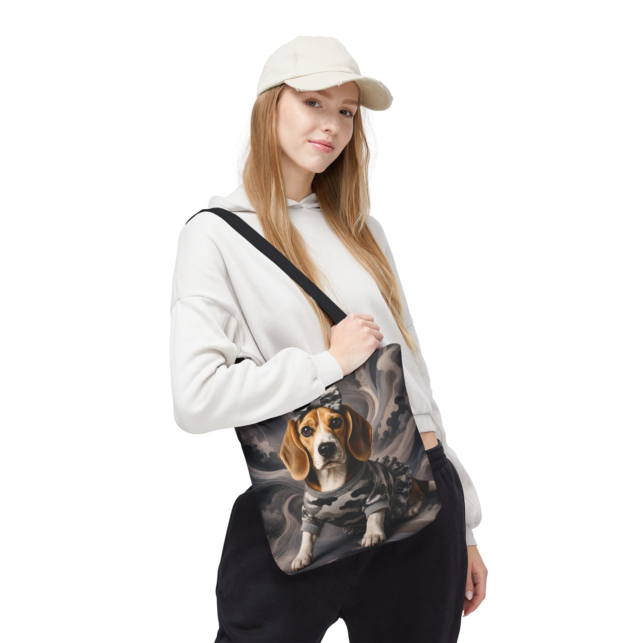 A woman wearing a beige cap, white hoodie, and black sweatpants carries a black shoulder bag featuring a printed graphic of a beagle dog in a camouflage jacket against a smoky gray background.