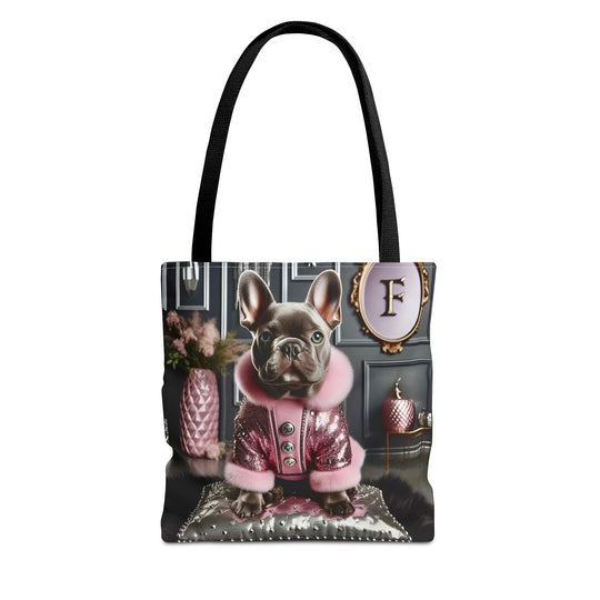 A tote bag with black handles featuring a printed graphic of a French Bulldog wearing a pink jacket in an elegant room, set against a plain white background.