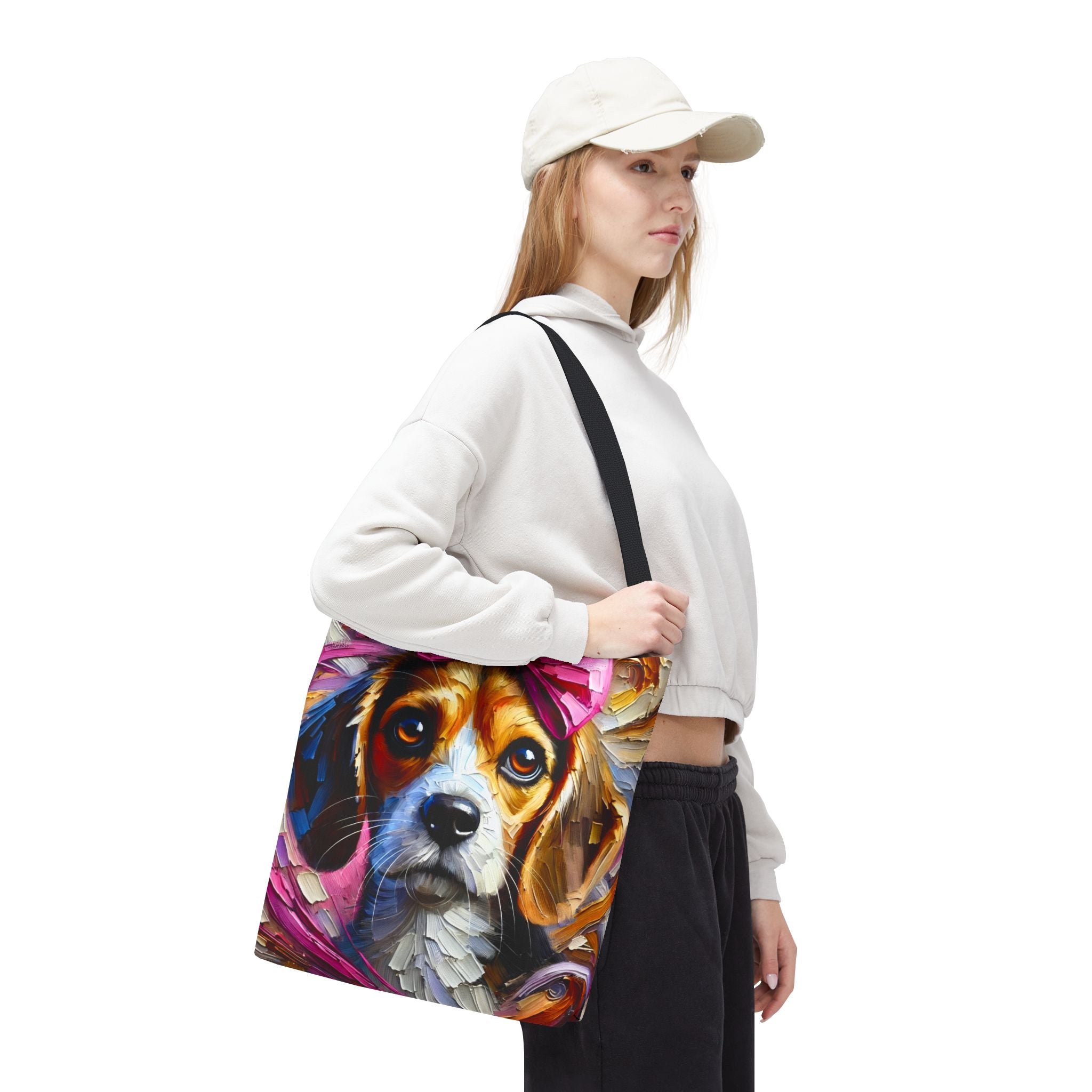 A woman wearing a white sweatshirt, black pants, and a white cap carries a large canvas tote bag featuring a colorful, painterly illustration of a beagle dog.