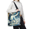 A person  carries a canvas tote bag with a black shoulder strap. The bag features a colorful abstract painting of a white Labrador retriever in blue, white, black, and beige tones.