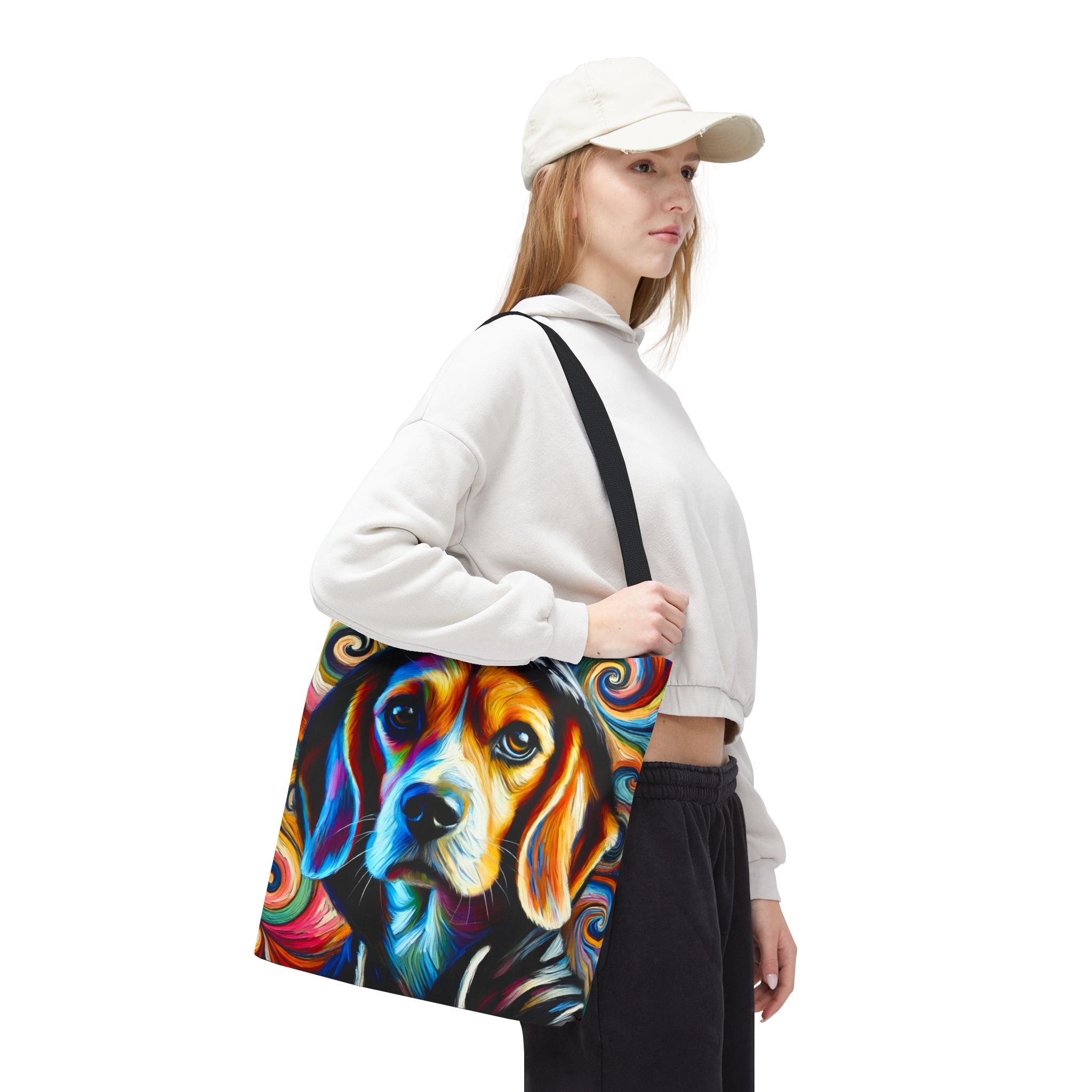 A woman wearing a white sweatshirt, black pants, and a white cap carries a canvas tote bag featuring a colorful, swirling abstract beagle dog print against a plain white background.