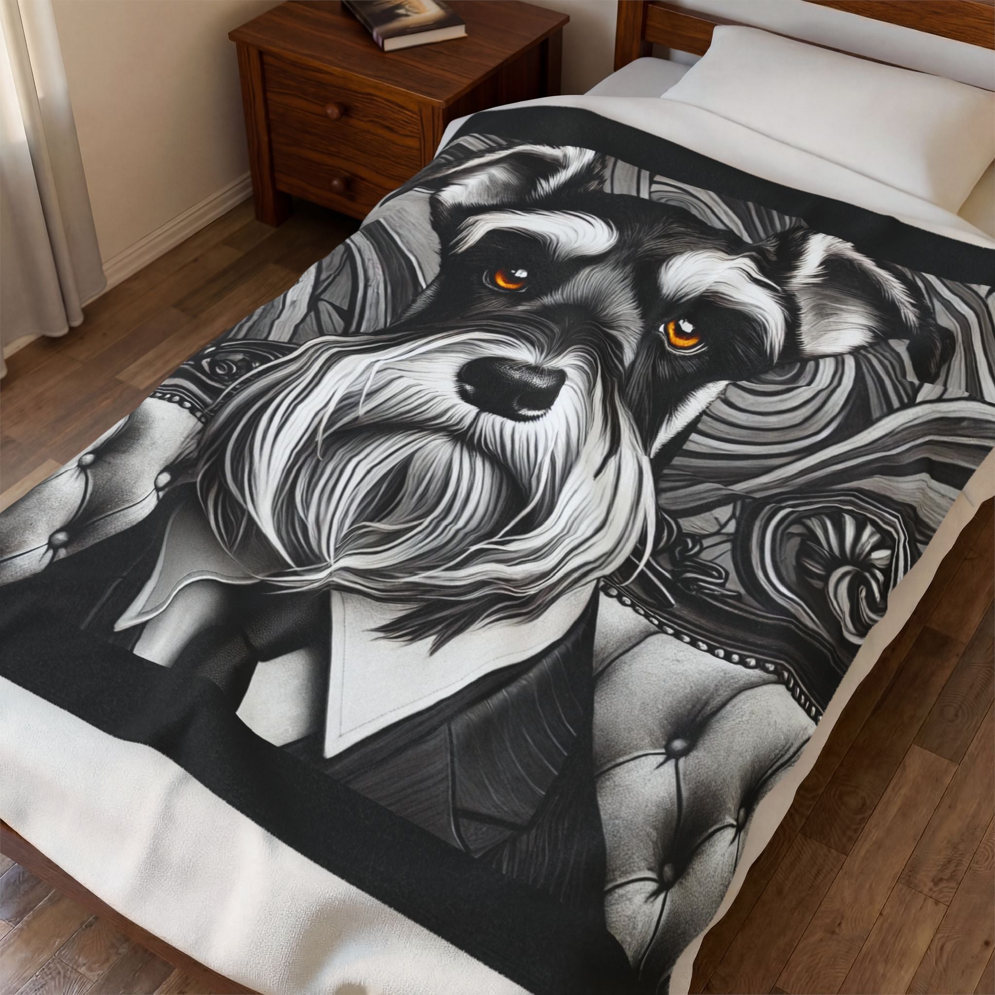 A black and white illustrated schnauzer blanket with orange eyes is shown on a bed in a bedroom setting.