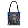 A tote bag featuring a stylized painting of a silver Labrador retriever's face surrounded by swirling blue, orange, and white artistic patterns, with black shoulder straps, shown against a plain white background.